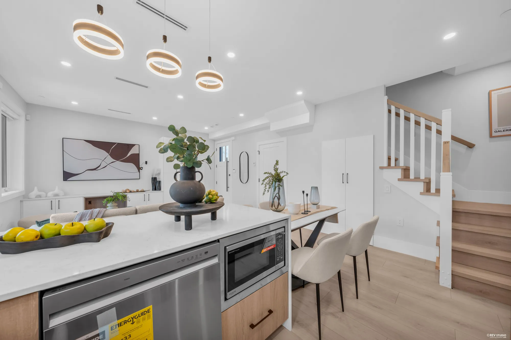 The peninsula end in waterfall quartz, the dishwasher, the ring pendants, the stair behind