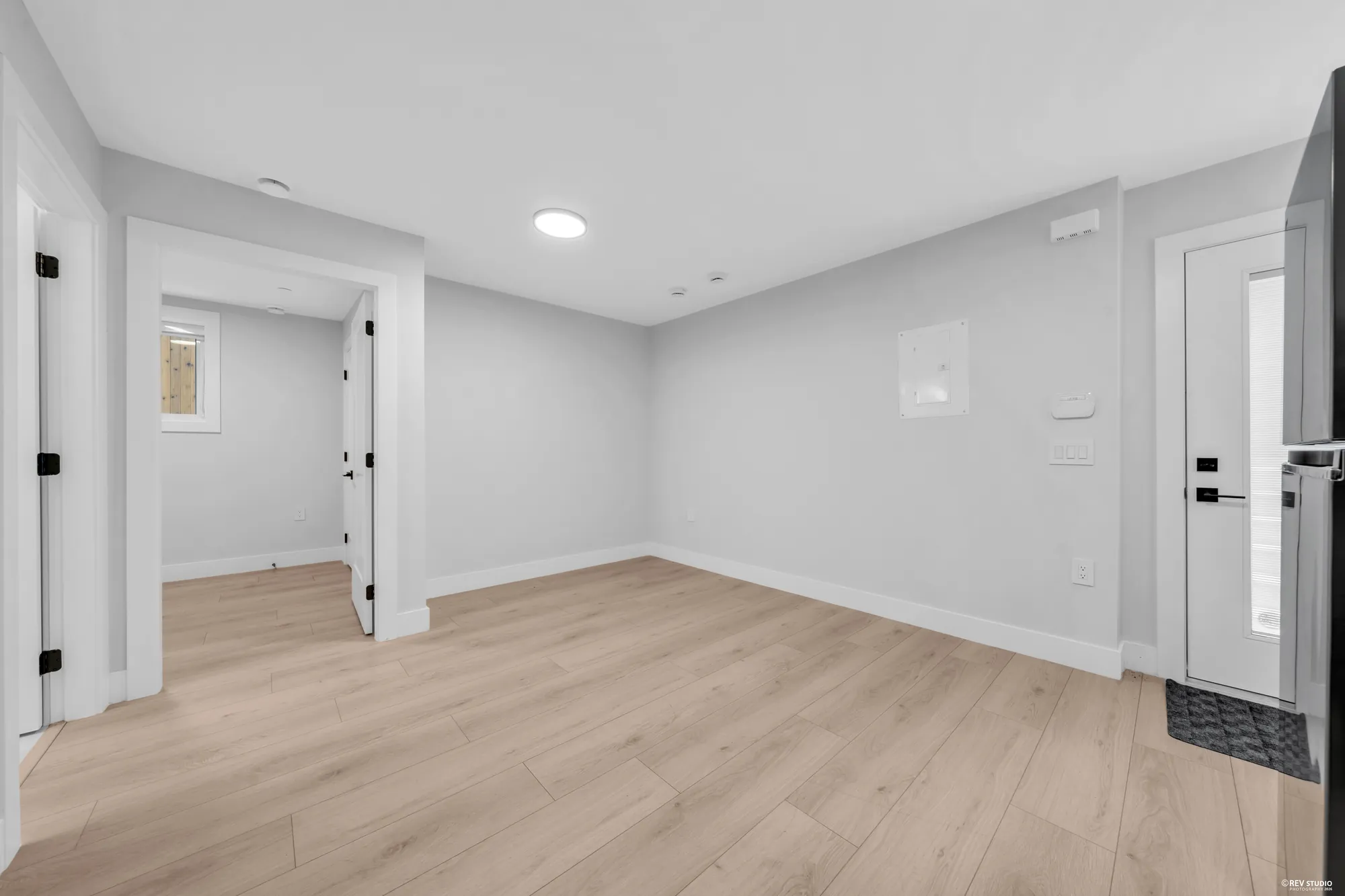 The lower living room toward the bedroom door and the closet, a small window high in the wall